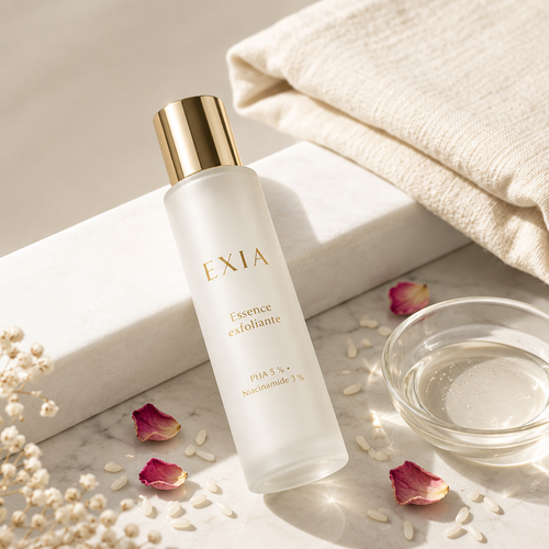 Essence exfoliante EXIA dans une mise en scène de soin avec pétales de rose
